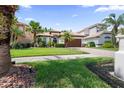 The house with a beautiful lawn, manicured shrubbery, and a paver driveway at 10880 Cory Lake Dr, Tampa, FL 33647