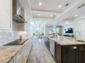 Modern kitchen with sleek appliances, a large island with seating, and an open layout to the dining and living areas at 1204 Derby Ln, Sarasota, FL 34242