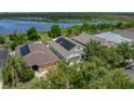 An aerial view of a home with solar panels, surrounded by lush greenery and a tranquil lake at 1701 Bonita Bluff Ct, Ruskin, FL 33570