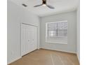Bright bedroom featuring sleek wood floors, a modern ceiling fan, and a closet for ample storage space at 1729 Arabian Ln, Palm Harbor, FL 34685