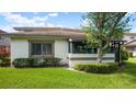Exterior view featuring lush lawn, manicured shrubbery, and architectural details of the home at 1851 Bough Ave # A, Clearwater, FL 33760