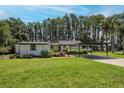 A charming single-story home with an attached carport set on a lush green lawn at 19209 Crooked Ln, Lutz, FL 33548