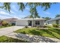 Single-story home with a two-car garage, landscaped lawn, and neutral-colored exterior at 2108 Delightful Dr, Ruskin, FL 33570
