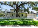 Charming two-story home with a well-manicured lawn, white picket fence, and mature tree shading the front yard at 238 7Th S Ave, Safety Harbor, FL 34695