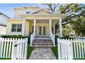 Charming two-story home features a welcoming front porch with white picket fence and lush landscaping at 238 7Th S Ave, Safety Harbor, FL 34695
