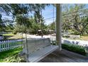 Relax on this charming front porch swing with a drink holder, overlooking the yard and quiet street at 238 7Th S Ave, Safety Harbor, FL 34695
