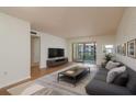 Bright living room with a sliding glass door to a balcony and wood-look flooring throughout at 2650 Countryside Blvd # C204, Clearwater, FL 33761