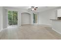 Sunlit living room featuring neutral walls, two glass sliding doors with large tile floor at 27563 Pleasure Ride Loop, Wesley Chapel, FL 33544