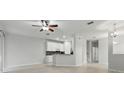 Open-concept living space with neutral walls, tile floors, and a kitchen area at 27563 Pleasure Ride Loop, Wesley Chapel, FL 33544