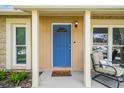 Close-up of front door with a charming blue color, decorative window, and welcoming mat at 3628 Dellefield St, New Port Richey, FL 34655