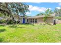Single-story home with stone accents, blue front door, and green lawn under a bright blue sky at 3641 Coppertree Cir, Brandon, FL 33511