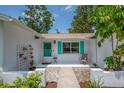 Inviting front porch with stylish turquoise door and shutters, creating a warm welcome at 3849 Hollow Oak Pl, Land O Lakes, FL 34639