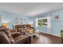Cozy living room with hardwood floors, comfortable leather seating, and ample natural light at 3849 Hollow Oak Pl, Land O Lakes, FL 34639