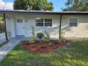 Inviting front entrance with landscaped garden, modern white door, and charming details at 4104 W Wisconsin Ave, Tampa, FL 33616