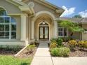 Elegant entryway with double glass doors and manicured landscaping at 4335 Clairidge Way, Palm Harbor, FL 34685