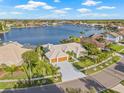 Aerial view of a home with a large lake in the background, palm trees, and well-maintained landscaping at 5002 E Longboat Blvd, Tampa, FL 33615