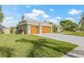 Beautiful single-story house with a gray driveway, brown garage doors, and a green lawn at 5002 E Longboat Blvd, Tampa, FL 33615