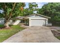 Inviting single-story home showcasing a well-manicured lawn, attached garage, and traditional design elements at 5210 Dr Martin Luther King Jr St N St, St Petersburg, FL 33703