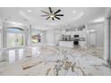 Open-concept living area with sleek, modern finishes, tray ceiling, and gorgeous marble floors at 5317 Lydia Ct, Spring Hill, FL 34608