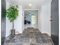 Inviting foyer with slate tile flooring, decorative plant, and view into the living area at 5625 Atlantic N Ave, St Petersburg, FL 33703