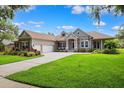 Inviting single-story home with lush front yard and well-maintained lawn with driveway and ample garage space at 5823 Terncrest Dr, Lithia, FL 33547