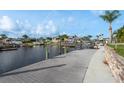 View of waterfront docks in a canal with boats in boat lifts and lush green landscaping at 6340 Garland Ct, New Port Richey, FL 34652