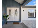Close up of front door with sidelight window and bird of paradise planter at 6841 Mitchell Cir, Tampa, FL 33634