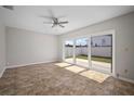 An empty living room featuring neutral walls, tile floors, and sliding glass door leading to backyard at 6841 Mitchell Cir, Tampa, FL 33634