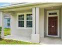 Welcoming front porch with sturdy support columns and dark wood front door at 7509 Tangle Bend Dr, Gibsonton, FL 33534