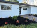 Inviting single-story home showcases fresh landscaping with black mulch and vibrant plants enhancing its curb appeal at 7703 Glenview Ln, Tampa, FL 33615