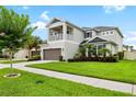 Attractive two-story home with balcony, two-car garage, and lush landscaping at 8019 Marbella Creek Ave, Tampa, FL 33625