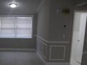 Bright living room showcasing wainscotting, neutral paint, and a large window for natural light at 8234 Ravencroft Dr, Tampa, FL 33615