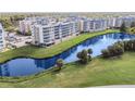 Aerial view of condos overlooking a large lake, featuring lush green surroundings and beautiful landscaping at 960 Starkey Rd # 7503, Largo, FL 33771
