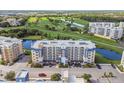 Exterior elevation of condo building with a manicured lawn, blue accents, and convenient parking at 960 Starkey Rd # 7503, Largo, FL 33771