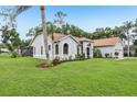 View of a one-story home with a well-manicured lawn and landscaping, and a screened in lanai in the back at 10113 Bell Creek Dr, Riverview, FL 33569
