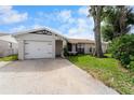 This house boasts a well-maintained front yard and attached garage, showcasing curb appeal and convenience at 10202 Bellhurst Ct, Tampa, FL 33615