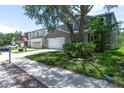 Street view showing the property's facade, two-car garage, and adjacent homes in the neighborhood at 10605 Marsanne Pl, Riverview, FL 33578