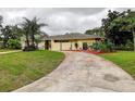 Beautiful home exterior featuring lush green grass and a winding driveway with manicured landscaping at 1117 S Florida Ave, Tarpon Springs, FL 34689