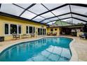 Inviting covered pool area with a clear blue pool surrounded by a tile deck and patio seating at 1117 S Florida Ave, Tarpon Springs, FL 34689