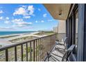 Balcony view overlooking a beautiful white sand beach, offering a serene retreat with comfortable seating and stunning coastal scenery at 1290 Gulf Blvd # 702, Clearwater Beach, FL 33767