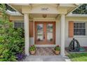 Inviting front entrance with a brick facade, double doors, and decorative potted plants at 14047 Briardale Ln, Tampa, FL 33618