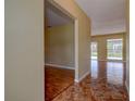 Open hallway with a mix of tile and wood floors leading to a living area with a view of the backyard at 14047 Briardale Ln, Tampa, FL 33618