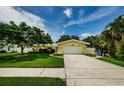 Lovely one-story yellow home featuring a wide driveway, attached garage, and well-maintained landscaping at 14534 Yacht Club Blvd, Seminole, FL 33776