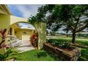 Inviting front yard with rocking chairs on the porch, colorful flowers, and a cozy, welcoming atmosphere at 14534 Yacht Club Blvd, Seminole, FL 33776