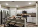 Modern kitchen features white cabinets, stainless steel appliances, a kitchen island with seating at 14819 Summer Branch Dr Dr, Lithia, FL 33547