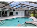 Inviting in-ground pool with screened enclosure and spa, perfect for outdoor relaxation and entertainment at 18004 Clear Lake Dr, Lutz, FL 33548