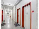 Long hallway with concrete floors and red trim around the doors to each unit at 2001 E 2Nd Ave # 37, Tampa, FL 33605
