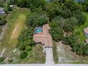 Aerial view of home with screened in pool in a lush, wooded area at 204 Oak Lake Dr, Spring Hill, FL 34608