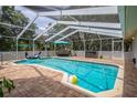 Inviting screened-in pool area with a refreshing pool, lounge furniture, and a playful inflatable toy at 204 Oak Lake Dr, Spring Hill, FL 34608