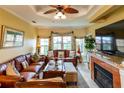 Inviting living room features a ceiling fan, fireplace, and comfortable leather furniture, perfect for relaxation and gatherings at 2724 Via Murano # 639, Clearwater, FL 33764